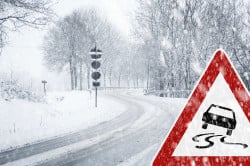 Snowy curvy road with traffic sign