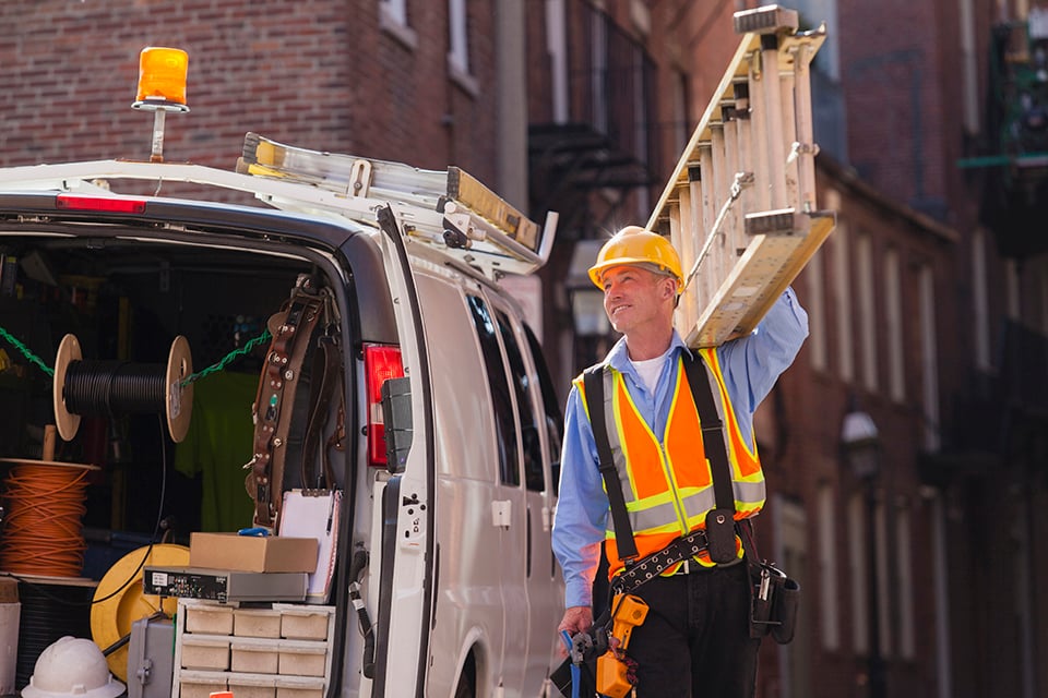 Kabelinstallateur bereidt zich voor om de lijn te beklimmen met ladder